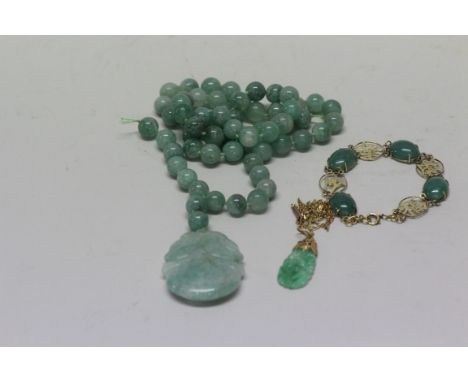 A Chinese gold and cabochon jade bracelet, stamped '14K'; together with another gold mounted carved and pierced jade pendant,