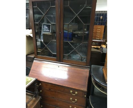 A Edwardian mahogany inlaid bureau bookcase the pair of glazed doors above a fall front with four drawers under on bracket fe
