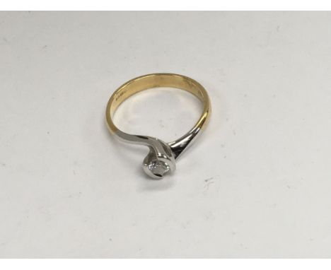 A 18 ct white and yellow gold ring inset with a single diamond.