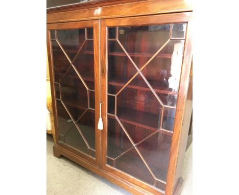 A Edwardian mahogany two door bookcase enclosing selfs on bracket feet 118 cm by 36 cm