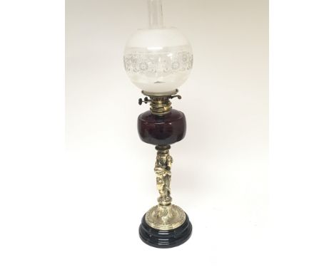 A Hinks late Victorian brass oil lamp the stem in the form of intertwined putti. With a ruby glass reservoir