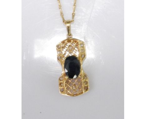 A yellow metal, sapphire and diamond filigree rectangular pendant, featuring a centre oval faceted sapphire in a claw setting