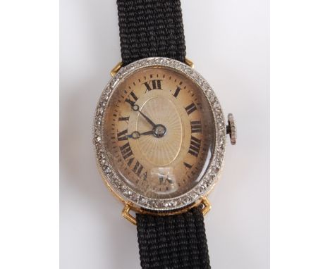 A lady's 18ct yellow gold manual wind cocktail wristwatch, featuring a discoloured oval Roman dial with an outer bezel set wi