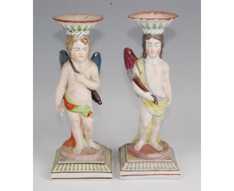 An early 19th century pearlware figural candlestick, modelled as a putti in standing pose, with hammer in hand, the sconce is