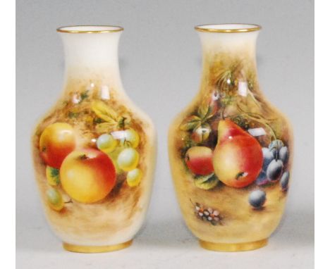 A Royal Worcester porcelain vase, shape No.2491, decorated with fruit on a mossy bank by Roberts, h.11.5cm; together with one