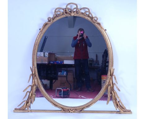 A Victorian gilt composition over-mantel mirror, the re-silvered oval plate in a ropetwist surround, further adorned with bul