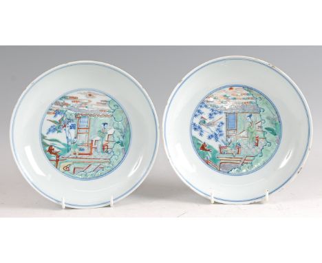 A pair of 18th century Chinese famille verte porcelain shallow bowls, each enamel decorated with figure landscape scenes in a