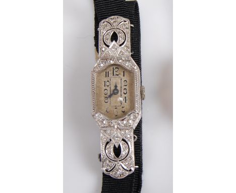 A white metal diamond set manual wind cocktail watch, having an oblong silver Arabic dial within an engraved openwork case gr