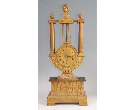 A mid-19th century French gilt metal lyre shaped mantel clock by Guyerdet of Paris, the whole surmounted with a classical bus