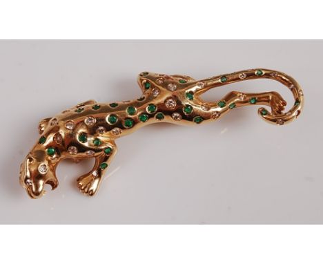 A yellow metal three-dimensional leopard brooch, inset with 38 round emeralds and 42 round brilliant cut diamonds, with a rol