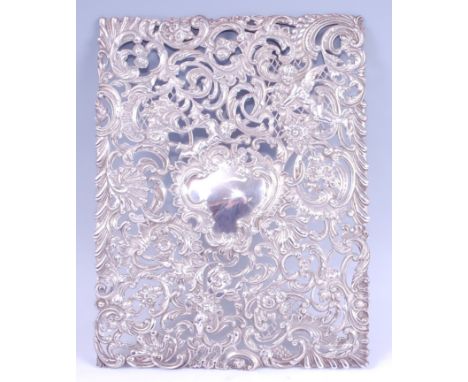 A late Victorian silver embossed panel, probably as removed from a desk-blotter or similar, having a central vacant cartouche