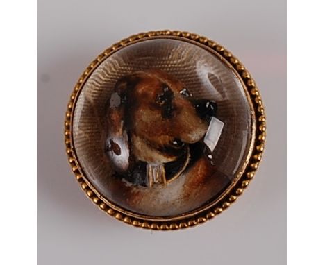 A yellow metal circular Essex crystal brooch, featuring the profile of a spaniel within a ropetwist surround, with hook fitti