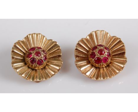 A pair of yellow metal Marguerite style cluster earrings, each comprising eight round rubies to the centre with a textured pe