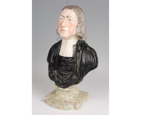 An early 19th century pearlware head and shoulders portrait bust of John Wesley, in clerical dress, on a shaped plinth, havin