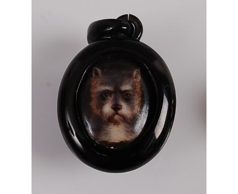 An oval jet pendant featuring a centre panel with painted dog's head , approx 45 x 27mm, gross weight 7.9gCondition report: S