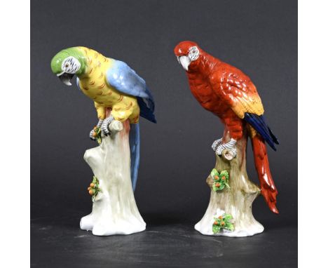 TWO GERMAN SITZENDORF PORCELAIN PARROTS. Two brightly painted Macaw's, each perched on a tree stump and with flowers and leav