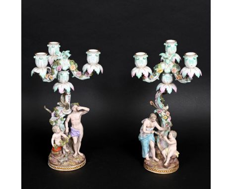 PAIR OF MEISSEN CANDLEABRA. A pair of candleabra, modelled with figures holding flowers and fruit, and each with seated cheru