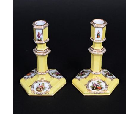 PAIR OF BERLIN PORCELAIN CANDLESTICKS. Of hexagonal shape, painted with courting couples within gilded panels and with a yell