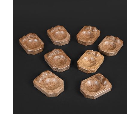 ROBERT THOMPSON OF KILBURN - SET OF MOUSEMAN DISHES. A set of 8 oak pin dishes by 'Mouseman', each with a small circular rece