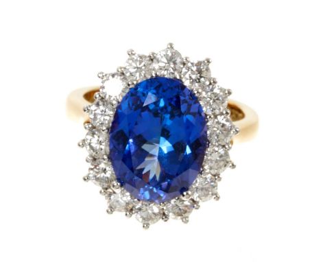 Good quality tanzanite and diamond cluster ring with an oval mixed cut tanzanite weighing approximately 4.97cts surrounded by