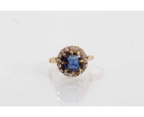 Sapphire and diamond cluster ring with a cushion shape mixed cut blue sapphire measuring approximately 7.3 x 6.7 x 2.5mm, sur