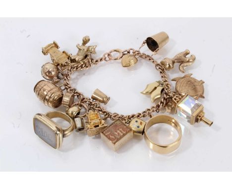 9ct gold charm bracelet with numerous gold charms to include an 18ct gold wedding ring and a regency gilt metal sealGross wei