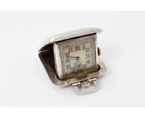 1930s Art Deco style silver cased travelling watch, in the form of a travelling case, with engine turned decoration and flip 