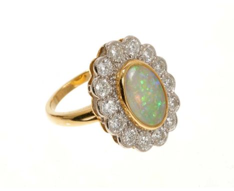 Opal and diamond cluster ring with an oval opal cabochon weighing 1.96ct surrounded by a border of brilliant cut diamonds wei