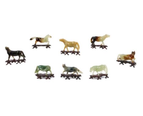 Set of eight early 20th century Chinese jade horses, each approximately 10cm long, with wooden stands, presented in cushioned
