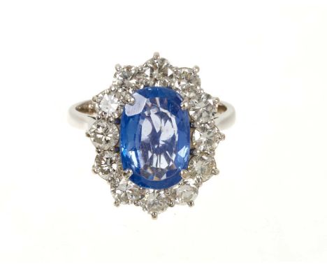 Sapphire and diamond cluster ring with an oval mixed cut cornflower blue weighing approximately 2.5-3.0cts surrounded by a bo