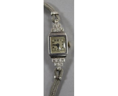 A lady's 1930's diamond and platinum manual wind cocktail watch, on a 9ct white gold twin strand bracelet.