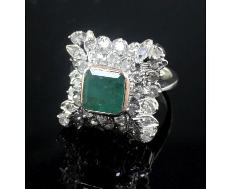 A 19th century style white gold, emerald and diamond cluster ring, of square form with raised setting, size K.