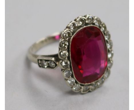 A mid 20th century platinum?, synthetic ruby and diamond set oval dress ring, size I.