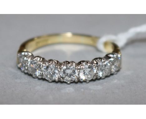 An 18ct gold and seven stone diamond half hoop ring, size R.