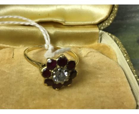 An 18ct ruby and diamond daisy ring