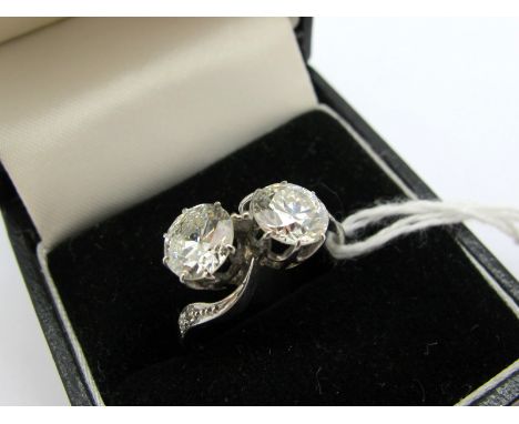 A Large Two Stone Diamond Ring, the (6mm) old cut stones claw set, of crossover design, between inset shoulders, indistinctly