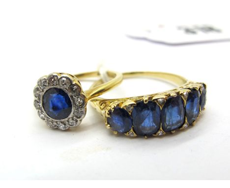 A Sapphire and Diamond Cluster Dress Ring, rubover set, stamped "18ct"; A Five Stone Ring, graduated oval set, scroll carved 