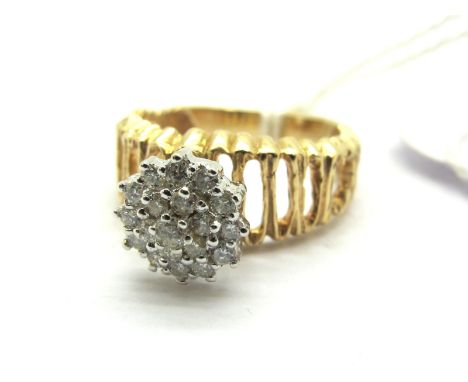 A Diamond Cluster Ring, claw set throughout with brilliant cut stones, above tapering openwork textured setting. *M&amp;S Jew