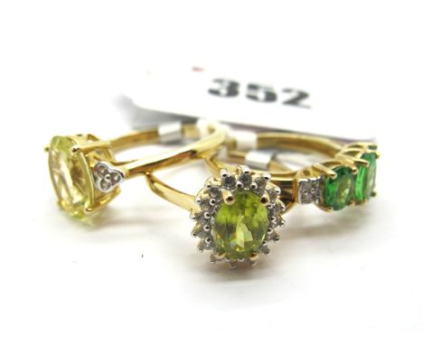 The Genuine Gemstone Company; A Modern 9ct Gold Cluster Dress Ring, oval claw set centre, within claw set border, between tap