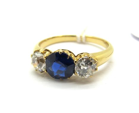 A Sapphire and Diamond Three Stone Ring, the central circular sapphire claw set between two old cut diamonds.