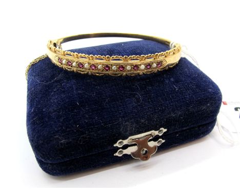 An Ornate 9ct Gold Victorian Style Bangle, alternate seed pearl and stone set highlights, within textured setting and openwor