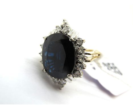 A Modern Cluster Dress Ring, with large claw set centre, within ornate claw set, border and modern bifurcated shoulders.