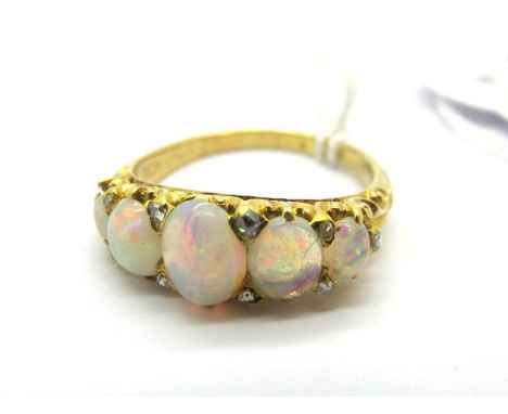 A Victorian Style Dress Ring, with graduated claw set cabochon highlights, within ornate textured setting and shoulders.