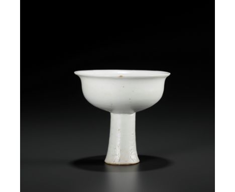 A WHITE GLAZED ANHUA DECORATED STEM CUP, YUAN DYNASTYChina, 1279-1368. Well potted with shallow sides flaring to an everted r