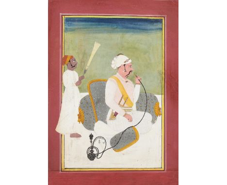 AN INDIAN MINIATURE PAINTING OF A MUGHAL PRINCE SMOKING A HUQQAIndia, Rajasthan, early 19th century. Watercolors and gold on 