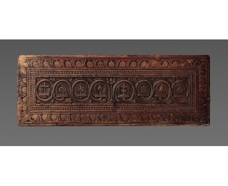 A CARVED WOOD 'EIGHT AUSPICIOUS SYMBOLS' MANUSCRIPT COVERTibet, 14th-15th century. Of rectangular form, finely carved in rece