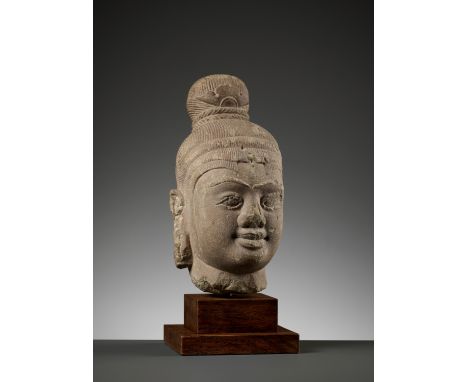 A SANDSTONE HEAD OF SHIVA, CHAM PERIODVietnam, 10th century. The serene face with almond-shaped eyes, elegantly curved brows,