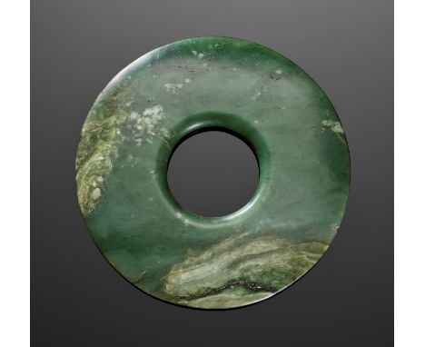 A GREEN JADE RING, HUAN, WARRING STATES PERIODChina, 5th-3rd century BC. Of circular form, tapering significantly from the ro