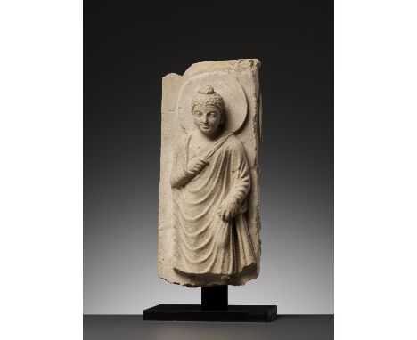 A GANDHARA STUCCO RELIEF OF BUDDHAAncient region of Kushan, 300 - 500 AD. Finely sculpted standing, holding the collar of his