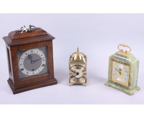 A mahogany cased mantel clock, an onyx cased mantel clock and a modern lantern clock